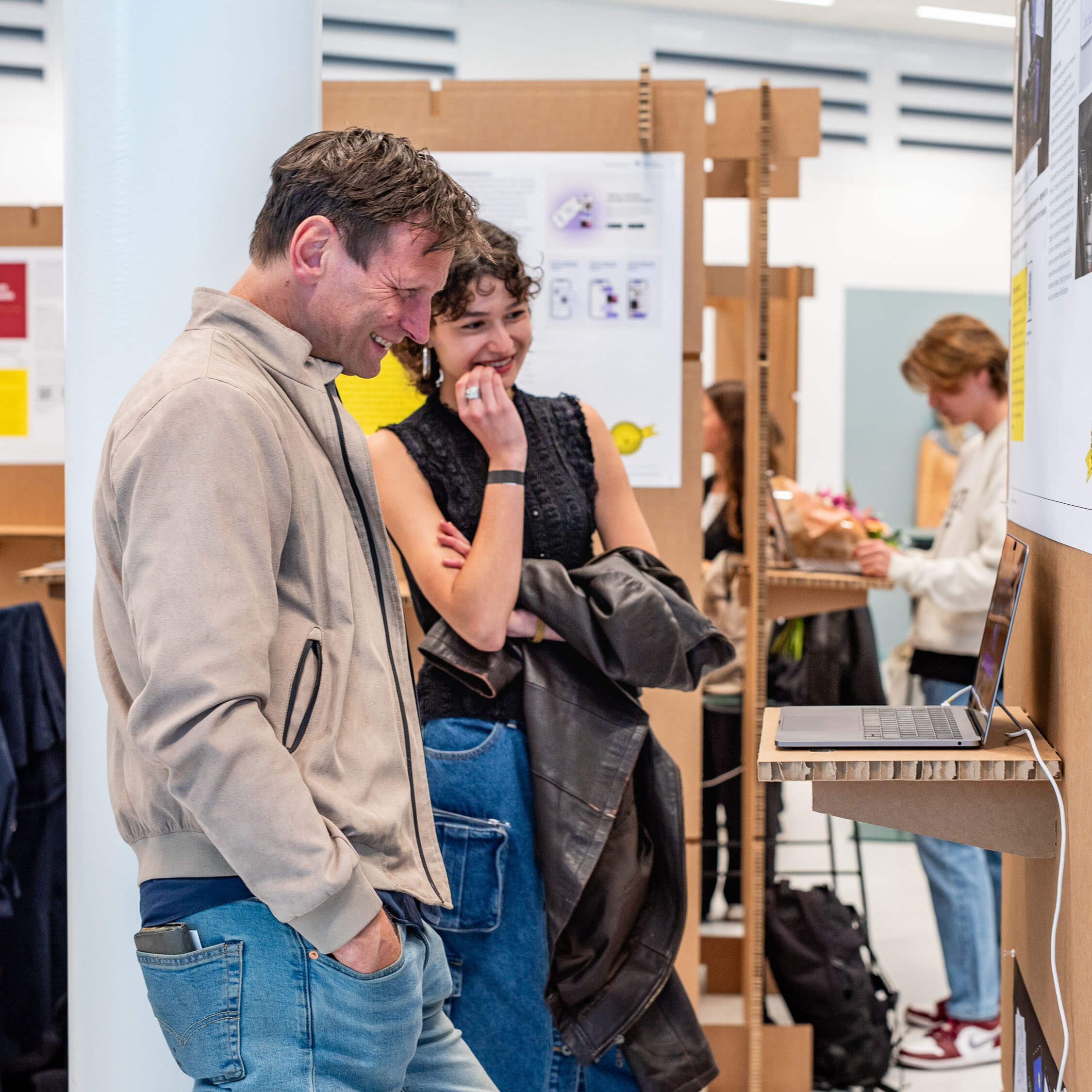 Two people looking proudly at student work