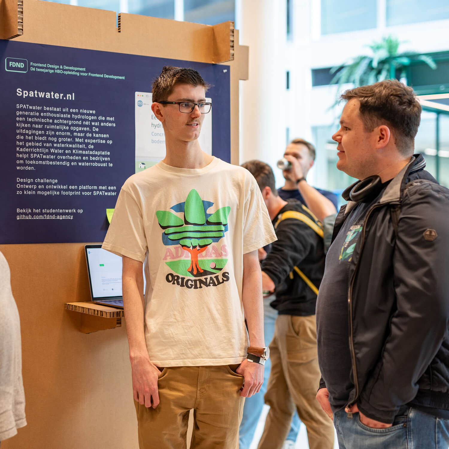 Two students of the Frontend Design and Development talking to each other